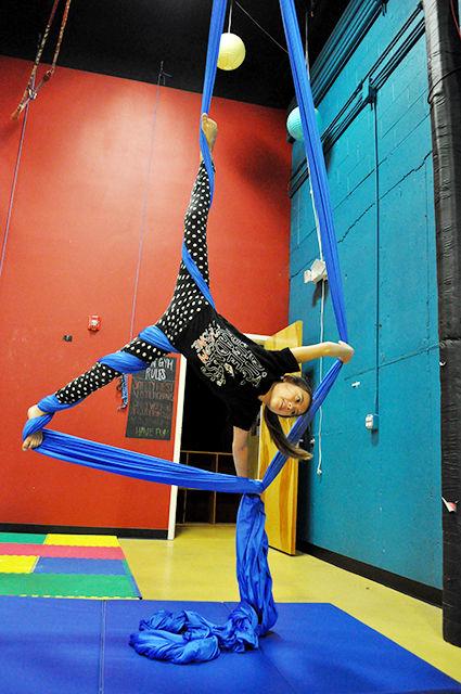 Alexa Hornshuh practices a pose on a silk in an aerial silks class taught by Brittany Storm at Cirque de Vol.