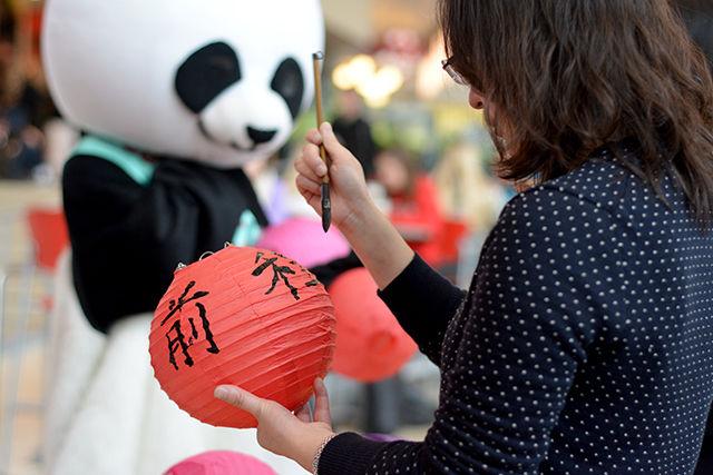 Li Mo, a professor who teaches and studies conversational Chinese, paints a custom message on a paper lantern on the 10th anniversary of the Confucius Institute event held at Talley Student Union on Tuesday. The Confucius Institute at NC State aims to foster better understanding of Chinese culture among students.
