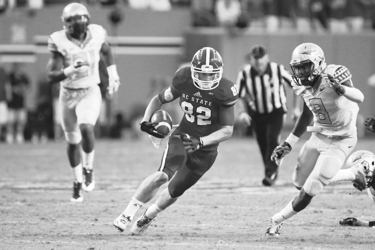 Freshman wide receiver Bo Hines carries the ball up the field against Florida State. Though the Wolfpack had 500 yards of offense, FSU pulled off the win 56-41 on Saturday, September 27th, 2014. Photo by Nick Faulkner