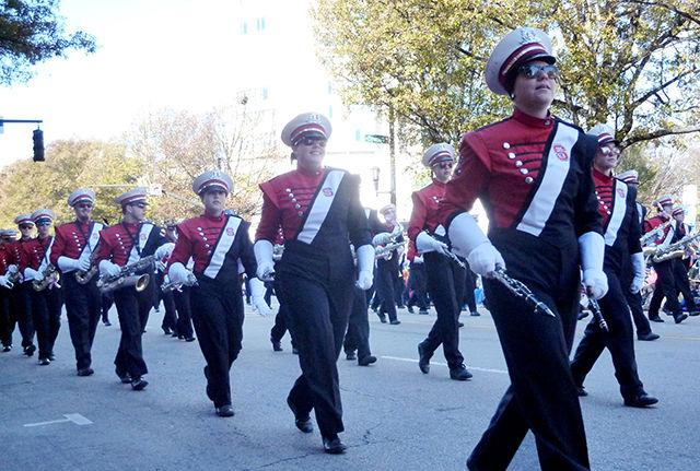 The NC State Power Sound of the South marches in the 70th annual Raleigh Christmas Parade downtown at the corner of S Harrington and Hillsborough streets on Saturday. It was one of 23 marching bands participating in this year's parade.