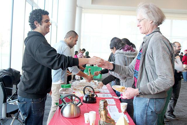 Islam Sayed, a PhD student in Electrical Engineering serves traditional Egyptian tea to Doug Greene, a volunteer of OIS at the International Tea Party organized by Office of Intrenational Services at Duke Energy Hall on Wednesday, November 19, 2014. It is annual event organized as a part of International Education Month, where all international students, scholars, and their spouses, to American students and faculty members of all departments, as well as members of the community are invited and learn and discuss about each others culture while enjoying tea and traditional snacks from their country.