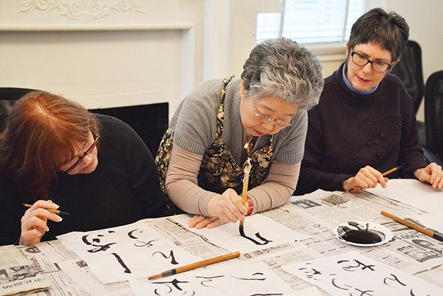 Sadako Salcagno sensei(center) teaches participants the art of Japanese Calligraphy during a cultural event called 'kakizome,' which is a term for the first calligraphy written at the beginning of the year. This event took place in NC Japan Center on Saturday, Jan 24. Shelley Eason(left) and Linda Watson(right) said it was their first visit to the Japan Center and Watson said "It was a great start to the new year. I appreciate the expertise and feeling of community that this place brings about."