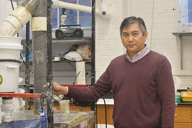 Dr. Francis de los Reyes, civil engineering professor and sanitation activist, stands next to a test set-up of "The Excrevator," the screw augur used to empty pit latrines in the developing world in the Environmental Engineering laboratory in Broughton Hall. "The worldwide sanitation problem is complex and involves not just technological challenges but also considers cultural, social, political, and business/finance issues" de Los Reyes said.