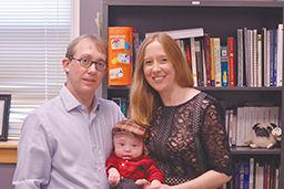 Dr.Kami A kosento, and Dr. Ryan J hurley with their son in Dr. Kami's office. Both of them are assistant professors in the CHASS in the communications department and have worked on various research projects together.