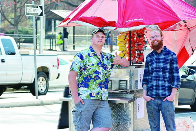 Travis &#8220;Country&#8221; Beard and Ben Douglas are two employees of Bearded Dogs of Raleigh, which operates a hot dog stand on the 2600 block of Hillsborough St as well as at large events. &#8220;We do big events like Comic-Con and St. Patty&#8217;s Day but we decided to bring it back up here on Hillsborough Street,&#8221; says Beard. Photo by Chris Rupert