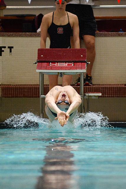 Freshman Hennessey Stuart launches off of the starting block at the start of the 100yd backstroke during NC State's meet with Minnesota Jan. 23 at the Casey Aquatic Center. Stuart finished the event with a first-place time of 47.50 and also claimed first-place finishes in the 200yd backstroke and the 400yd medley relay. Both the No. 8 men's (201-127) and No. 16 women's teams (189-145) recorded victories over the Golden Gophers.