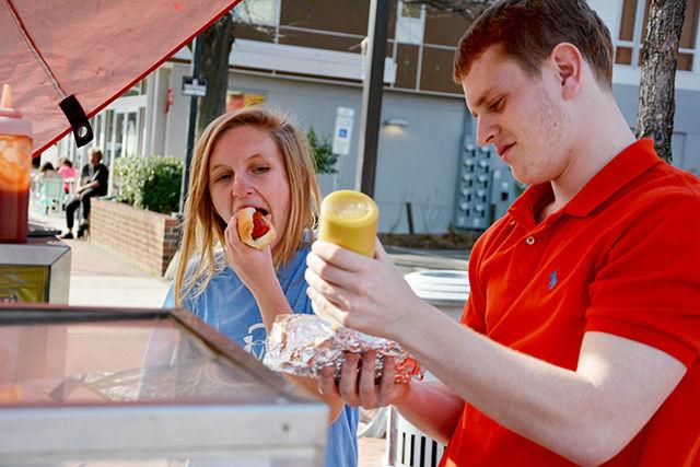 Kathryn Covington, a freshman in parks, recreation and tourism and Rob Wood, a Wake Tech student eat hot dogs Tuesday March 24th on Hillsborough St. "Hot dogs are my favorite food and I'm a big critic and I love these hot dogs," said Covington.