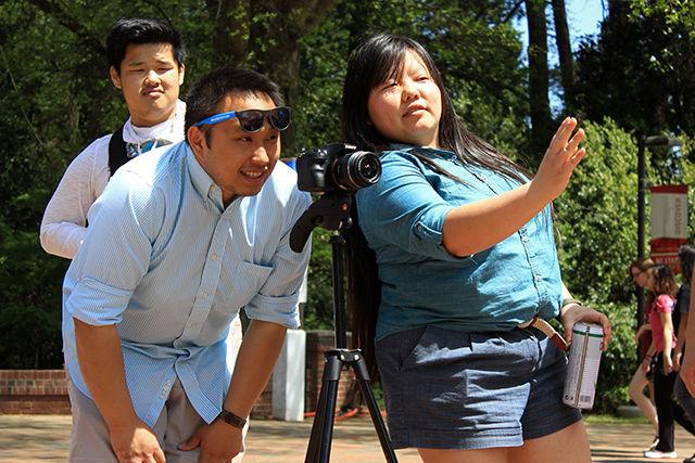 Kou Vang, a junior majoring in biochemistry, discusses the script with his friend S Suda Thao, an NC State alumna, while filming a video near Talley Student Union on Sunday. Vang and his group belong to the Hmong Student Association which aims to bring cultural awareness to the NC State students and local community. "Today we are filming a video with the theme of &#8216;Run with the pack&#8217;. This video is the opening video to our event on [Saturday] where we bring a group of Hmong high school students from the Catawba and Burke county area to tour NC State. Our goal is to promote higher education and diversity to a young group of students," Thao said.