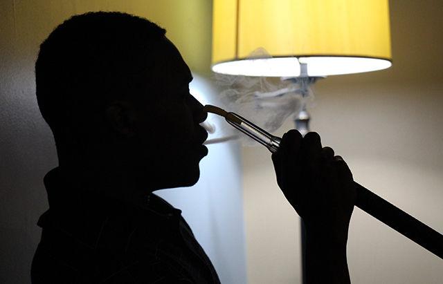 Jaffton Garett, a student at Wake Technological Community College, smokes from hookah at the Fuzion Lounge and Cafe whilst enjoying the soccer match playing on television. The new bar, recently opened on Hillsborough Street, possesses the ambience of a hookah bar as well as a coffee shop.