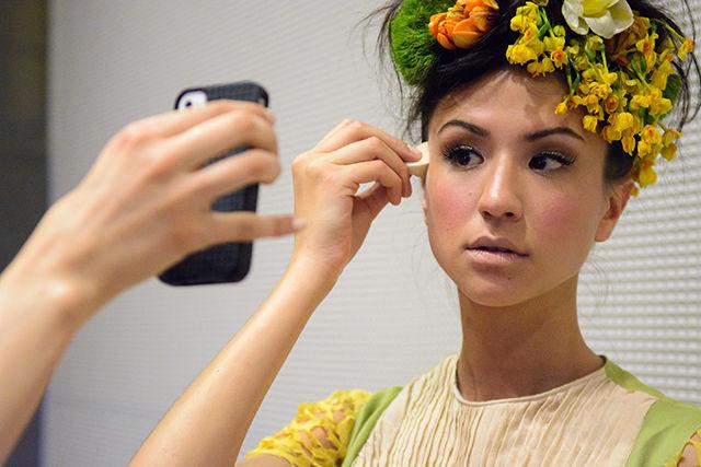 Junior studying anthropology Maria Savoy, modeling for junior Anni Albers scholar Rachel Bridge's collection Efflorescence, puts the final touches on her makeup before the Art2Wear fashion show held in Talley Student Union April 25, 2014.
