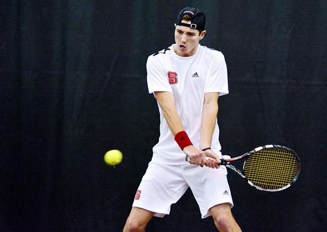 Sophomore Ian Dempster watches the ball into his racquet before making a backhand return during his and teammate Robbie Mudge's doubles matchup against Northwestern's Alex Pasareanu and Mihir Kumar Friday, Jan. 16, 2015 at the J.W. Tennis Center. Dempster and Mudge went on to win the match 6-3, aiding in NC State's narrow 4-3 victory over the No. 34-ranked Wildcats.