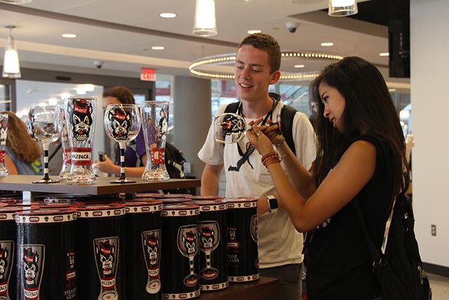 Tamara Lee, an incoming freshman in Ins=dustrial Engineering and Vance Stiles, attending summer camp for material science, look at different varieties of glasses displayed at Wolfpack Outfitters store in Talley. The store made its grand opening on Monday, June 22, 2015.