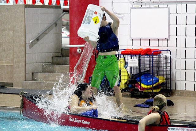 Connor Wagner, sophomore in electrical and computer engineering, pours down water on Sydney flake, freshman in polymer and color chemistry to sink their ship and help his team canoe win the game. Pool Battleship was organized as a part of Intramural sports at Casey Aquatic Centre on Saturday, July 25, 2015.