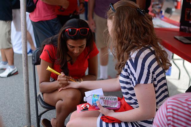 Crli Kvietok, a freshman in the College of Textiles, draws a henna tattoo onto Clarissa Rainear, a freshman studying computer science.