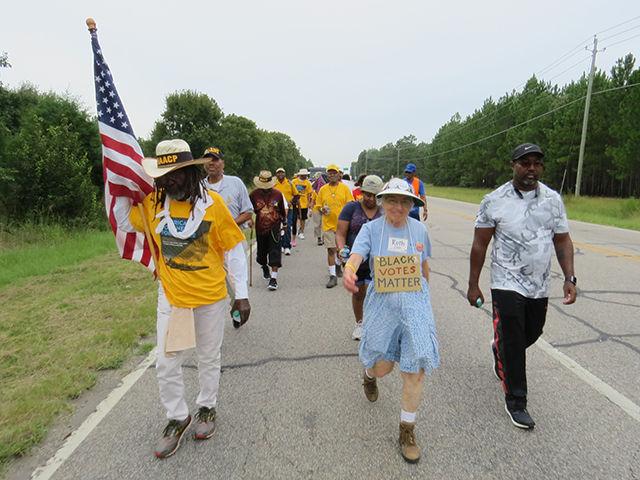 From left, Brother Middle Passage, 65, Ruth Zalph, 88, and Kevin Myles, Eastern Division field director of the NAACP, march at the front of the demonstration on Sunday as part of the first leg of the journey through North Carolina. Brother Middle Passage recently recovered from heart surgery but has kept the pace for much of the march for a total of nearly 600 miles.&#160;