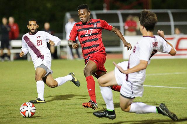 Redshirt Junior Midfielder Philip Carmon drives the ball past two Virginia Tech players. The Wolfpack lost a heartbreaking match 2-3 against Virginia Tech on Friday, September 26th, 2014. Photo by Nick Faulkner