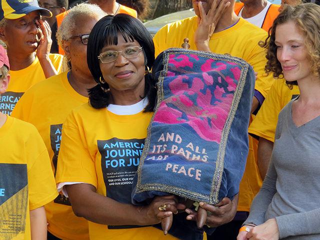 Pastor Mattie Nichols holds a scroll of the Jewish Torah, which has been carried since the beginning of the march as it was during the civil rights marches of the '60s. The scrolls weighed close to 20 pounds and were passed around to marchers as others got tired.&#160;