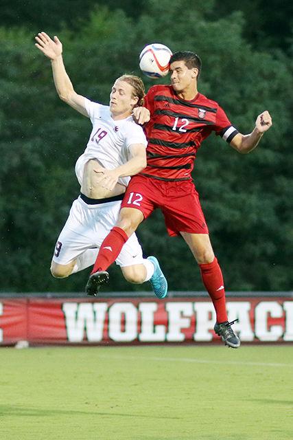 Holden Fender, a senior midfielder heads the ball forward, away from Elon defender Nathan Diehl during the postponed exhibition against Elon. Fender played 60 minutes of the 2-3 heartbreaker at Dail Soccer Stadium on August 20th.