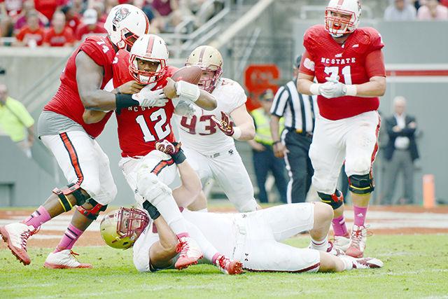 Redshirt junior quarterback Jacoby Brissett is sacked by Boston College defenders Saturday, Oct. 11, 2014, at Carter-Finley Stadium. Brissett was sacked 4 times during the game. The Wolfpack tacked on another loss to the season on a score of 14-30, taking their season record to 4-3 and 0-3 in conference play.&#160;