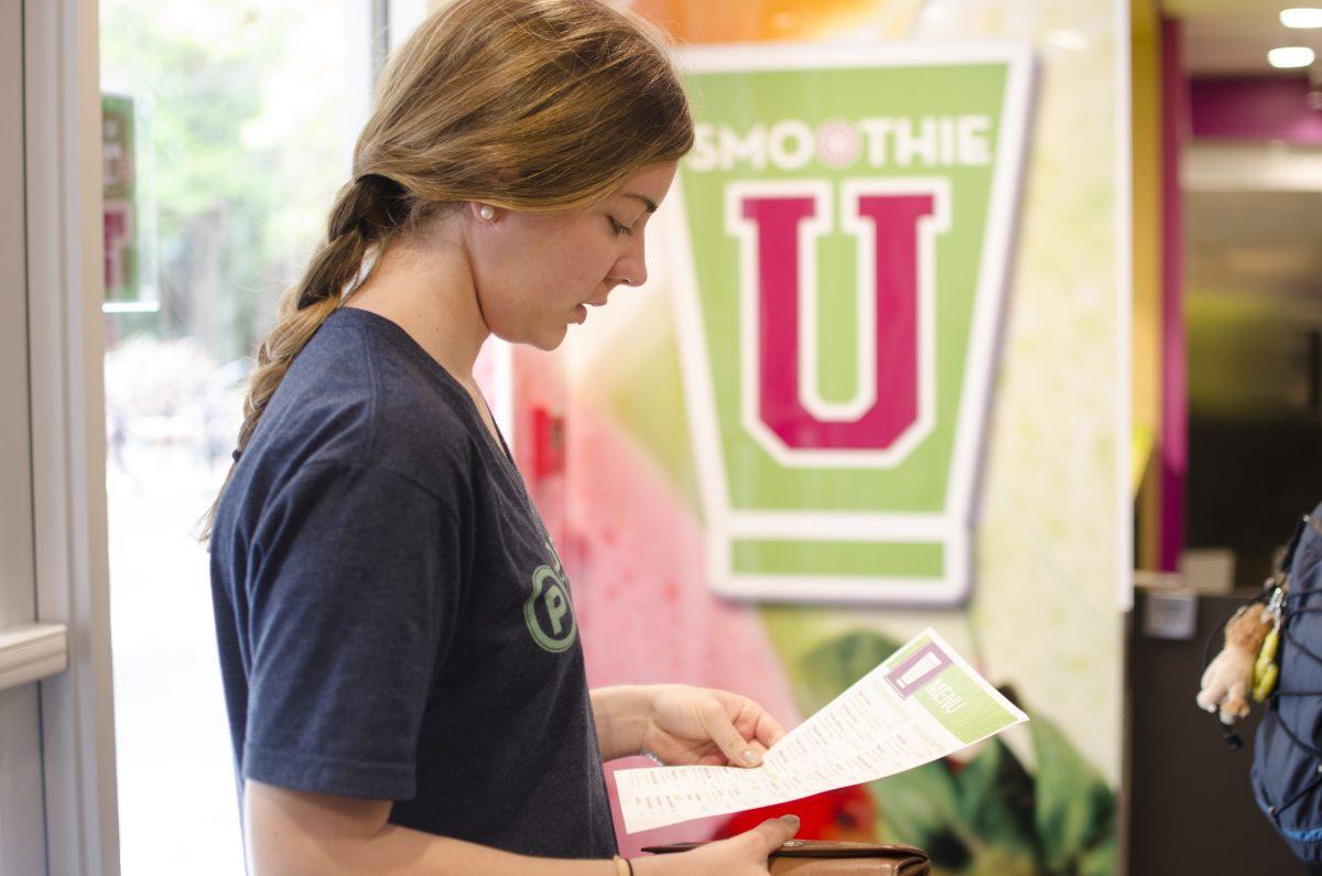 Tahlia K&#246;stenberger, Sophomore in Applied Nutrution, waits for her peach sunset smoothie at the opening of "Smoothie U" in the Atrium on April 20th. K&#246;stenberger commented that she usually drinks about one smoothie a week from Port City Java and found out about "Smoothie U" from an email she recieved last week from University Dining. Upperclassman patrons compared it "Freshens", the previous smoothie store, with mixed reviews.