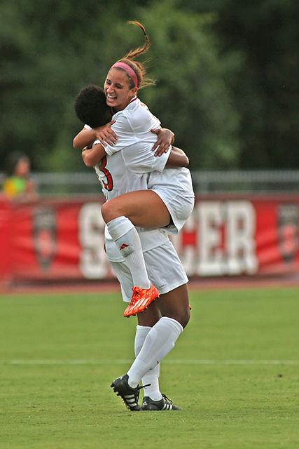 Redshirt junion defender Dayna Tomayko leaps into the arms of freshman midfielder Ella Bonner after Bonner's first goal. The Wolfpack took down the Elon Phoenix 2-0 in Dail Soccer Stadium on August 27th.