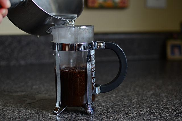 Next, add hot, boiled water to the coffee grounds. Put the top on the carafe and let steep for four minutes.
