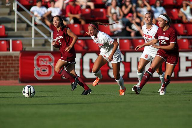 Redshirt Junior Dayna Tomayko chases down a passed ball as Senior Forward Caroline Gentry provides backup. Tomayko had two shots on goal during the exhibition against #11 South Carolina. The Pack lost the 3 period exhibition 0-3 on August 14th at Dail Soccer Stadium.