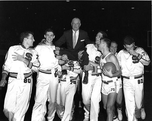 NC State College basketball players lifting coach Everett Case on their shoulders after winning 1955 ACC championship.