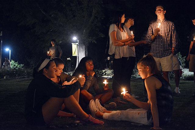 A group gathers together on Stafford Commons Tuesday night at the end of the candlelit vigil held for freshman Joseph Banks. The vigil included speeches from several members of the NC State community, as well as a moment of silence for Banks. Several people came together at the end of the vigil in prayer circles, embraces, and discussions of the vigil.