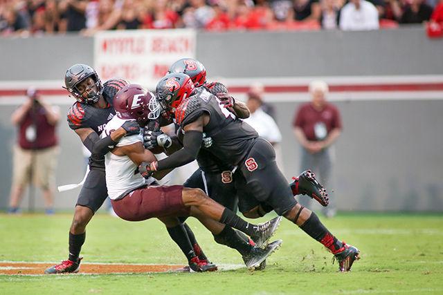 The Wolfpack defense comes together to take down an Eastern Kentucky player during the 35-0 shutout against the Eastern Kentucky Colonels in Carter-Finley Stadium on Sept. 12.