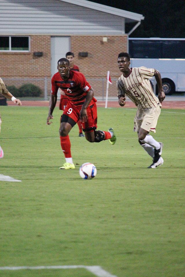Sophomore midfielder Ade Taiwo runs to steal the ball from College of Charleston's Cornell Holland at Dail Soccer Stadium August 31, 2015. The Wolfpack celebrated a 2-0 victory over the Cougars.