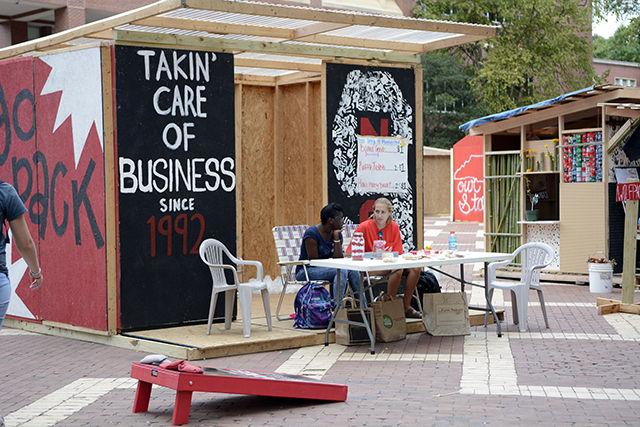 Jabou Sonko and Emily Musselwhite, juniors studying business administration, sit outside the Poole College of Management shack at Shack-A-Thon on Sept. 22. To raise money for Habitat for Humanity Sonko and Musselwhite sold baked goods, raffle tickets, and a chance to guess how many beads were placed in a jar. Last year the Poole College of Management raised over $6,600 in donations.
