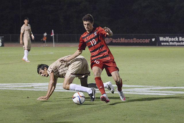 Freshman forward Clayton Sparks gains possession over the ball against a Charleston defender. The Wolfpack won the game 2-0 on Aug. 31 at Dail Soccer Stadium.