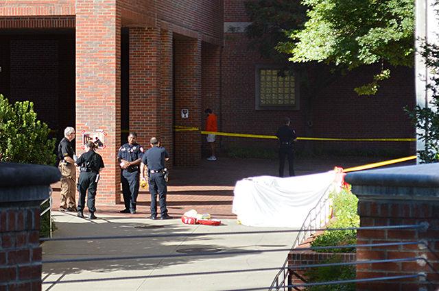 NC State police officers, as seen from the crosswalk connecting Dabney Hall to Yarbrough Drive, gather between Dabney Hall and Cox Hall to discuss an ongoing death investigation during the afternoon of September 14th.