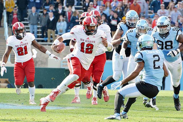 Redshirt junior quarterback Jacoby Brissett runs the ball downfield Saturday Nov. 30, 2014 at Kenan Stadium. The Wolfpack defeated the Tar Heels 35-7. Brissett begins his final season with the Wolfpack Saturday against Troy.