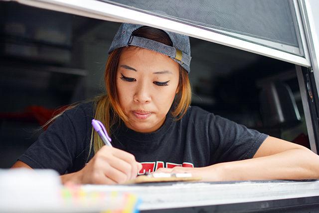 Sunny Lin writes down an order for one of the items on their menu. Pho Nomenal Dumplings won the sixth season of The Great Food Truck Race.