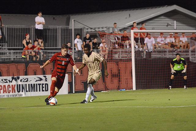Sophomore forward Ryan Peterson dribbles the ball away from College of Charleston midfielder Cornell Holland. The Pack scored each half, winning the game 2-0 on Aug. 31.