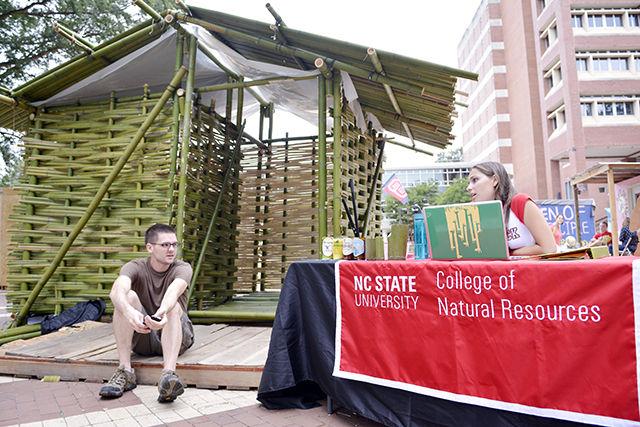 Darren Stebbins, a senior studying forestry, discusses with Miranda Day, junior studying parks, recreation and tourism management and head of fundraising for the College of Natural Resources shack about ways to help raise money for Habitat for Humanity during the weekly fundraiser Shack-a-Thon at the Brickyard Monday, Sep. 21, 2015. Their shack is made out of bamboo and according to build coordinator for the shack and senior studying forest management Dillon Dunn, it took hundreds of hours to build and involved the use of a machete. Also, the bamboo came from Hill Forest in Roxboro. When asked what the inspiration was to build the shack, "I enjoy plants, and I wanted to combine my love of plants with my love of building. Bamboo was an obvious choice for me" Dunn said. "For me, involvement in Shack-a-thon is really meaningful. I love seeing the N.C. State community come together and fundraise for a comon goal- to help provide someone in the best city of the world with a home. What we are all doing here this week is really impactful and its an honor and privilege to be a part of it" Day said.