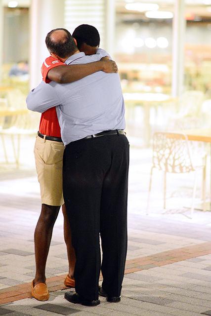 Student Body President Khari Cyrus hugs Mike Giancola, assistant vice provost, after he delivers a speech to the crowd gathered on Stafford Commons Tuesday, September 15. The candlelight vigil was in memory of Joseph A. Banks after he died on Monday.