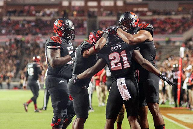 Junior running back Matt Dayes celebrates with teammates after a touchdown. Dayes had an explosive day with three touchdowns on 116 rushing yards. The Wolfpack had a dominant performance during the 35-0 shutout against the Eastern Kentucky Colonels in Carter-Finley Stadium on Saturday.
