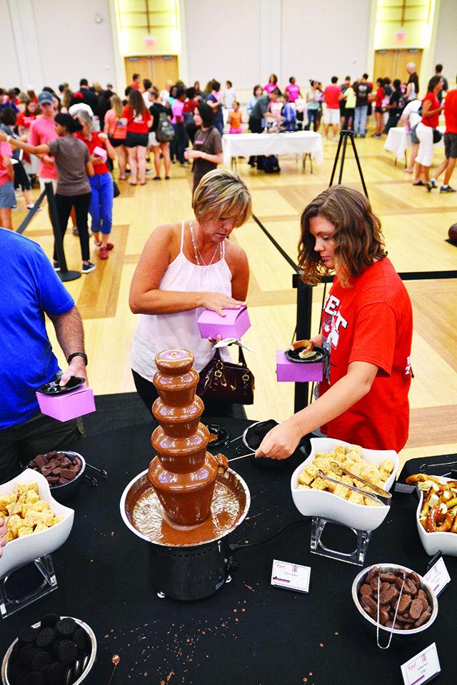 Hailey Hendricks, a freshman studying exploratory studies, and her mother dip marshmallows into the chocolate fountain in the Talley Ballroom during the Chocolate Festival, Friday, Sept. 11, 2015.