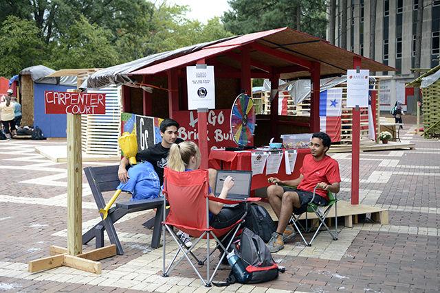 Skylare Smith, a junior studying animal science, Nishant Singh, a freshman studying industrial engineering, and Sampit Panda, a sophomore studying biomedical engineering and biology, sit outside the Goodnight Scholars shack at Shack-A-Thon Sept. 22 on the brickyard. Their shack charged $1 for people to spin a wheel to win prizes such as free Insomnia Cookies and a coupon for Groucho's Deli in order to raise money for Habitat for Humanity.