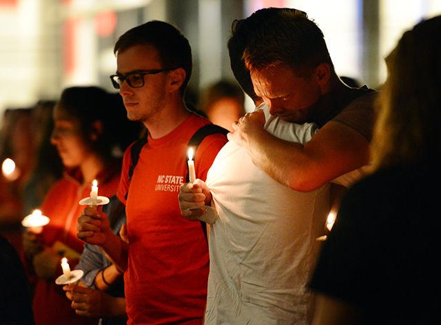 Calvin Putnam, a sophomore studying marine science, hugs Usman Abbasi, a junior studying business, after the candlelight vigil for Joseph Banks held on Stafford Commons Tuesday night.