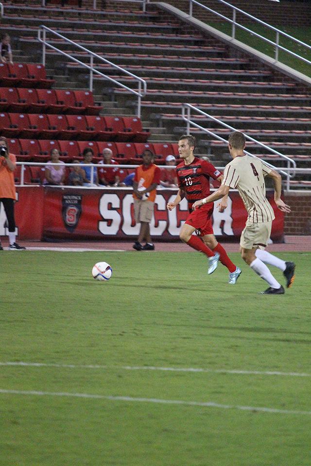 Sophomore midfielder Zach Knudson carries the ball, keeping it away from College of Charleston's Lorenz Esposito. Knudson attempted two shots throughout the game. The Wolfpack defeated the Cougars by 2-0, with one goal made in each half.
