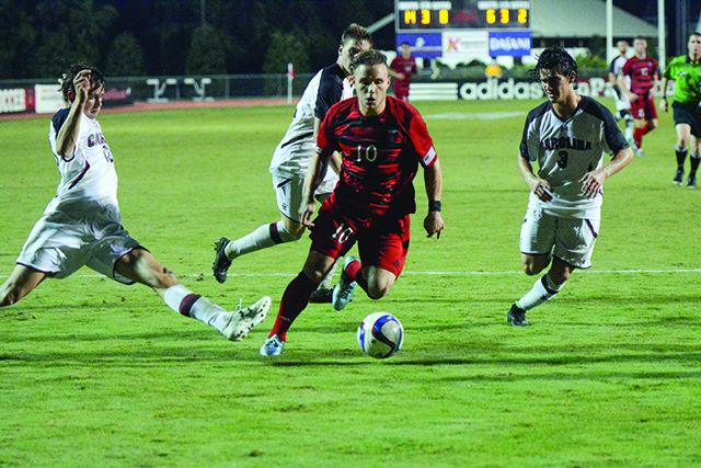 Sophomore Zach Knudson a midfielder sprints past Gamecock defenders to shoot the ball. Knudson took three shots Tuesday night and made one. The NC State mens soccer team won 2-1 against South Carolina on October 13th at Dail Soccer Stadium.