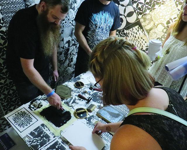 Students create their own prints in the UNCG Art Truck using ink and engraved wood blocks. This attraction gave a hands-on approach to showing how M.C. Escher created many of his works. The Art Truck was a part of College Night at the North Carolina Museum of Art on Friday, Oct. 23, 2015.