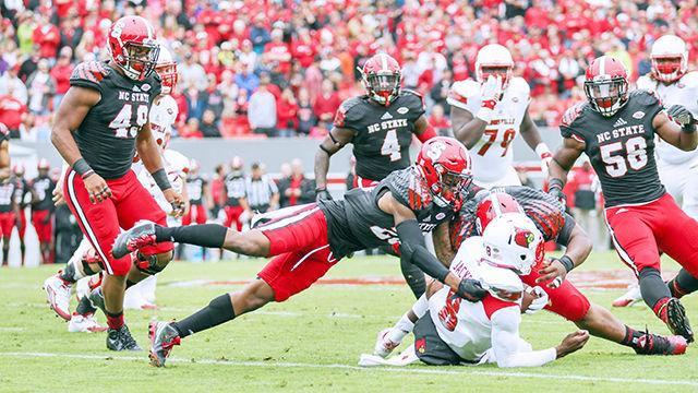 Sophomore cornerback Mike Stevens and Wolfpack defenders tackle Cardinals freshman quarterback Lamar Jackson. Stevens finished the game with four tackles and half-credit for a tackle for a loss. NC State was defeated 13-20 against the Louisville Cardinals in Carter-Finley Stadium on Oct. 3, 2015.