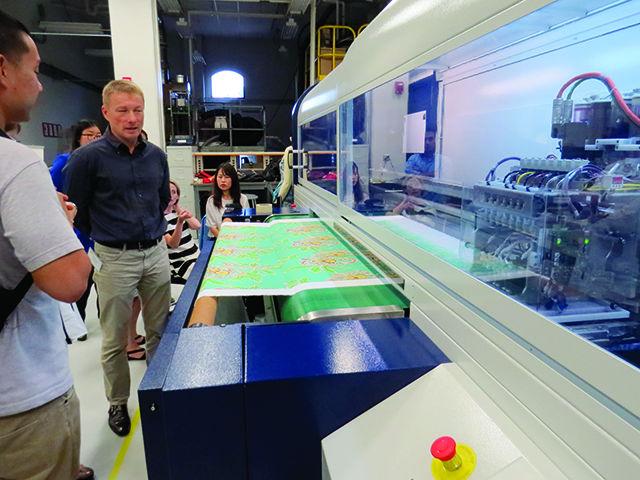 The new digital textile printer printing a design in the new lab as visitors look on at the College of Textiles on Wednesday. A ribbon cutting ceremony was held to unveil the new machine, the first model used in the United States. A demonstration of the system&#8217;s capabilities showed that the new machines are capable of printing complex designs onto natural and synthetic fabric at a rate of 100 meters per hour using four colors and 50 meters per hour using eight colors; a fraction of the time it used to take to produce comparable goods in the past.