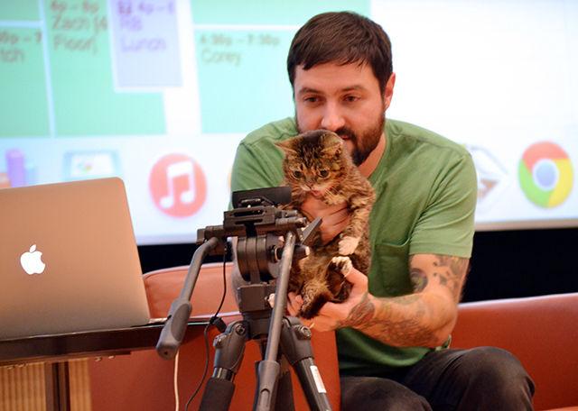 Mike Bridavsky holds Lil BUB up to a camera so the crowd of hundreds can get a better look at her on the screen in Hunt Library&#8217;s auditorium on Monday, Oct. 26, 2015. Bridavsky presented their story as part of Creativity and Technology Symposium programs (C.A.T.S.).