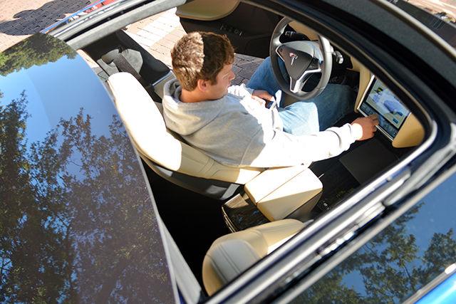 Stuart Avant, a freshman studying general agriculture, tries to close the sunroof of the Model S Tesla while inside it at the Alternative Vehicle showcase on the Brickyard Wednesday. "It's a pretty neat showcase," Avant said. "It makes you strive to succeed in life."
